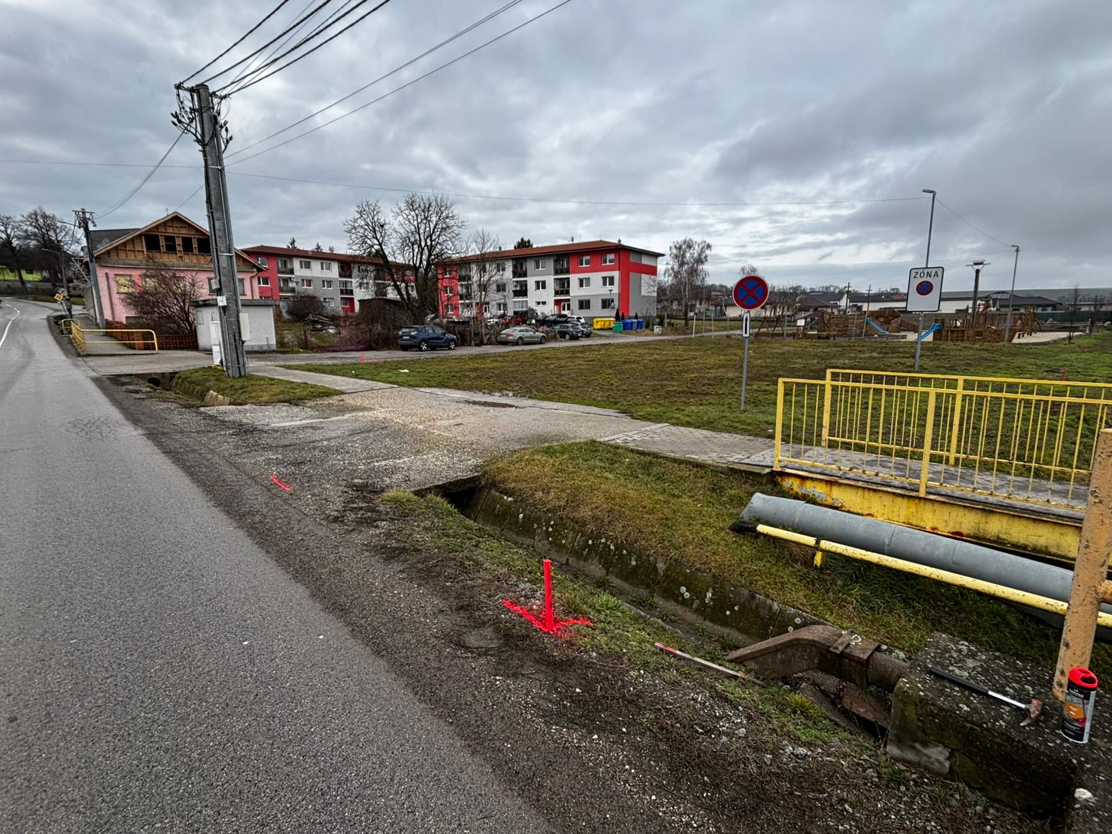 PRED — pohľad z prístupovej cesty na pozemok a okolitú zástavbu (existujúce bytové domy, detské ihrisko).