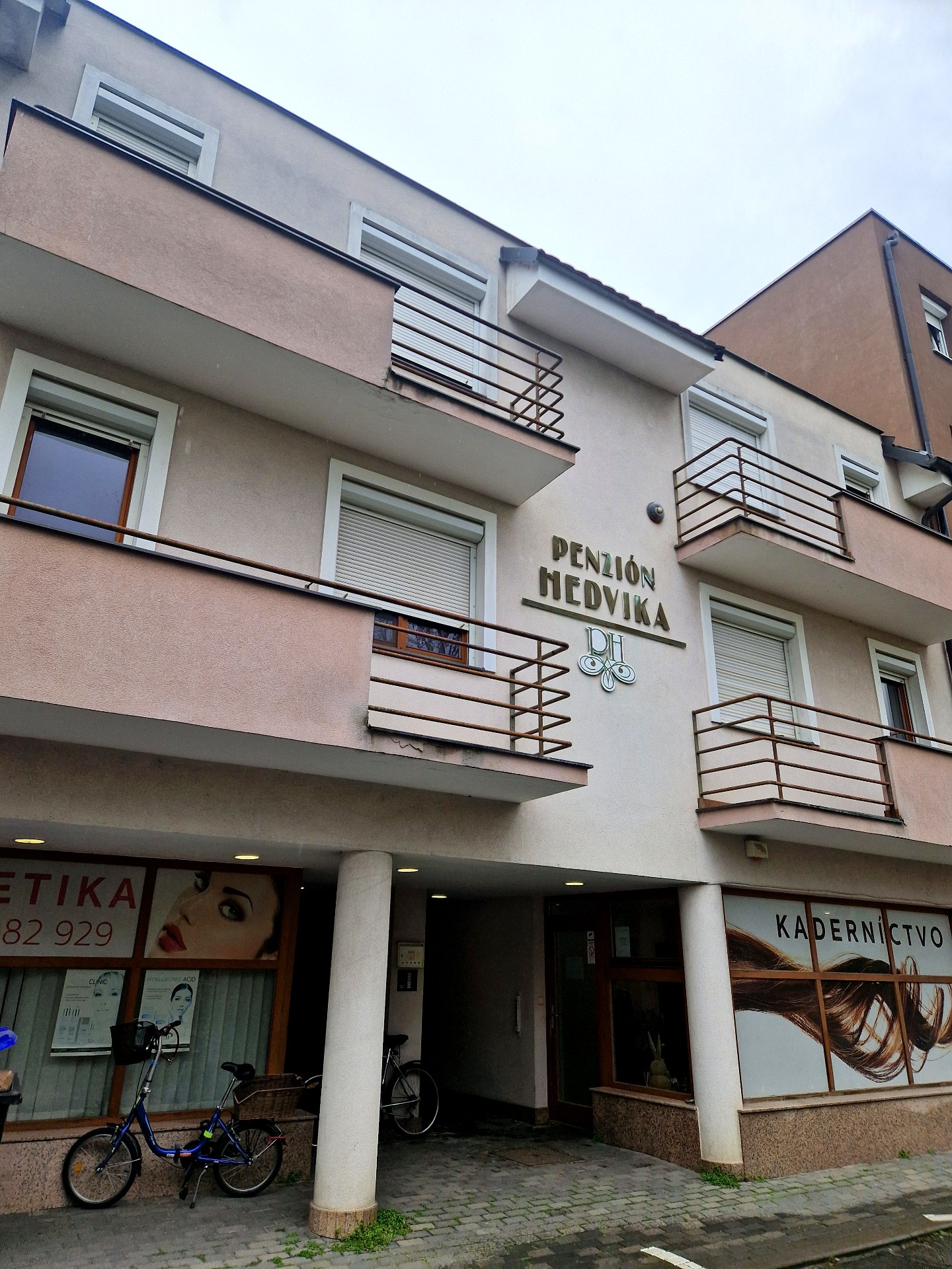 PRED rekonštrukciou — pôvodná ružová fasáda, hrdzavejúce zábradlia, opotrebovaný stav