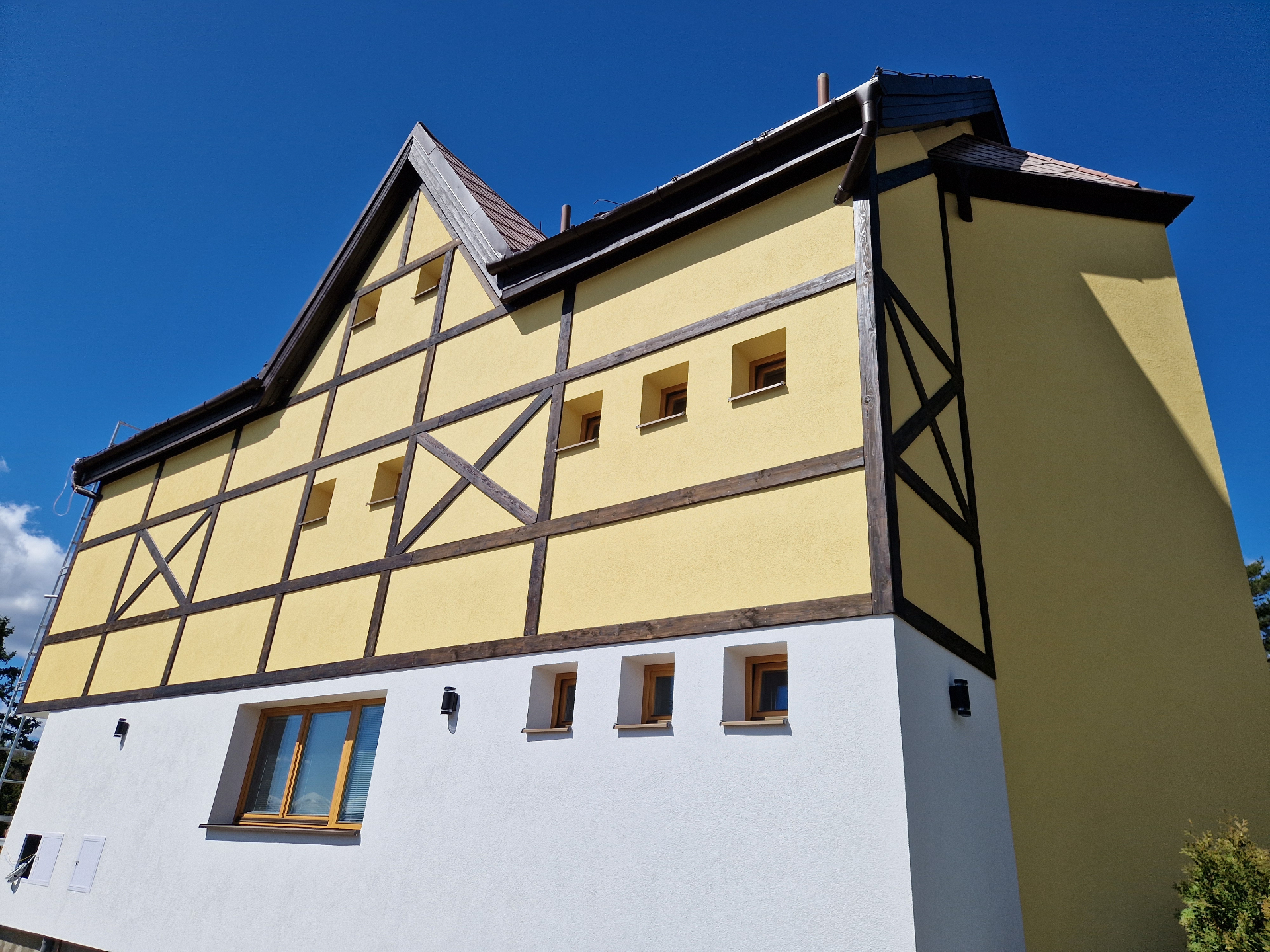 Hikers Paradise — bočná fasáda po rekonštrukcii (2025) s viditeľným hrazdením, novou omietkou a bielym soklom.