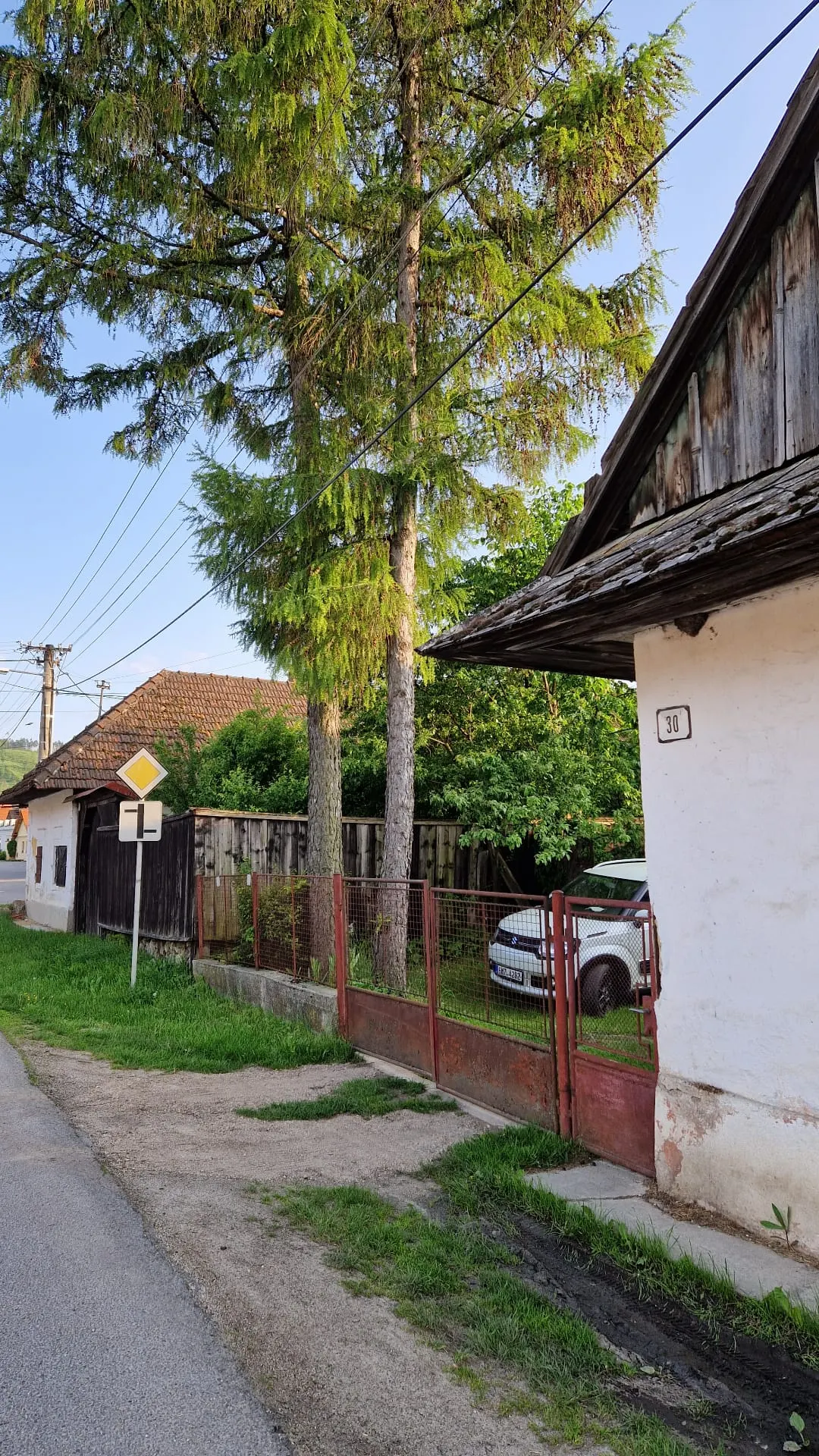 PRED rekonštrukciou (05/2023) — pohľad z ulice s charakteristickým modřínom (larix), po ktorom je penzión pomenovaný; v pozadí ďalšia historická zástavba obce Blatnica