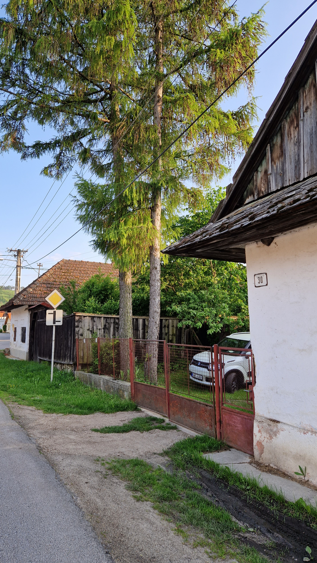 PRED rekonštrukciou (05/2023) — pohľad z ulice s charakteristickým modřínom (larix), po ktorom je penzión pomenovaný; v pozadí ďalšia historická zástavba obce Blatnica