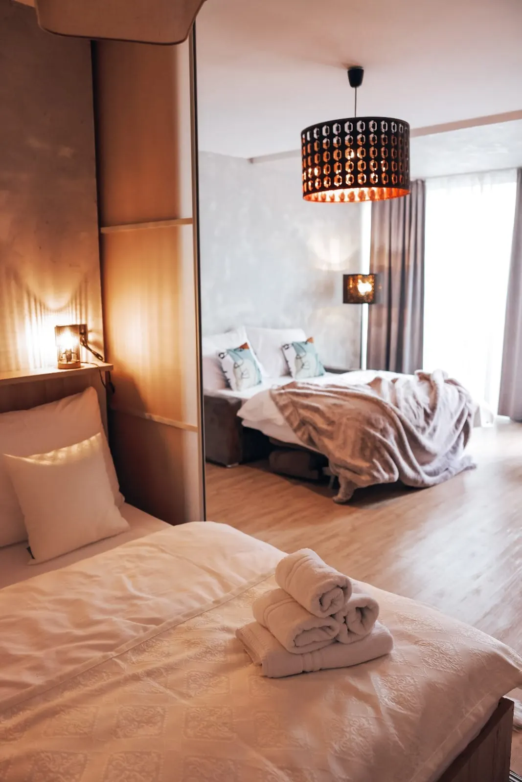 Ukážka typového apartmánu — spálňová časť, posedenie a vlastná kúpeľňa, vybavenie zodpovedajúce wellness pobytom.