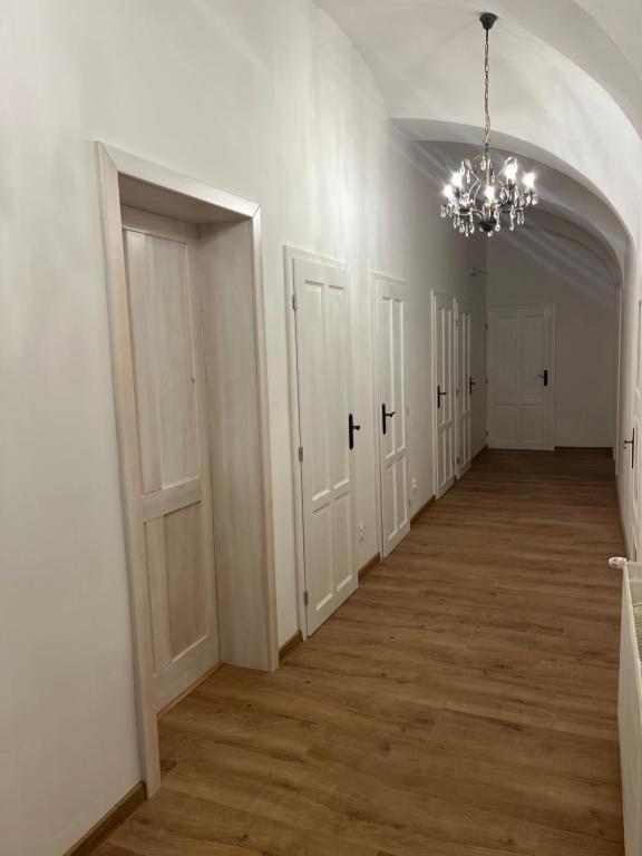 Centrálna chodba s klenutým stropom a dobovými dverami — citlivá obnova historickej dispozície.